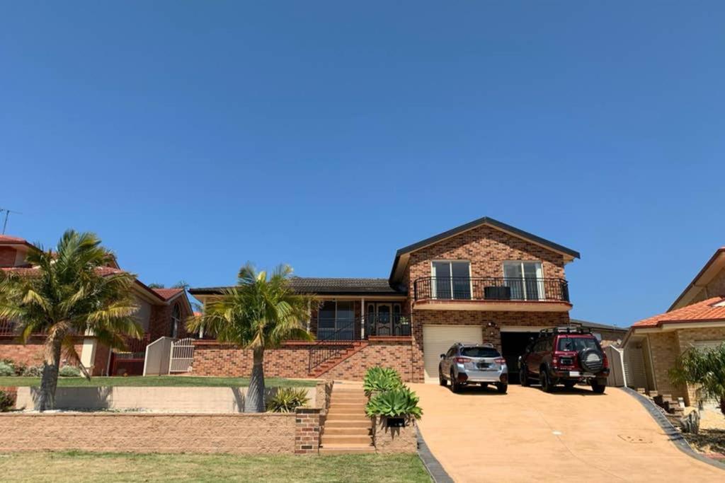 蚬壳港Shellharbour. Ocean, lake and mountain view的两辆车停在车道的房子