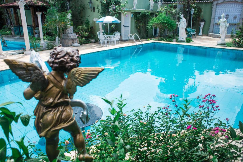 瓜鲁雅Pernambuco Club House的游泳池旁的天使雕像
