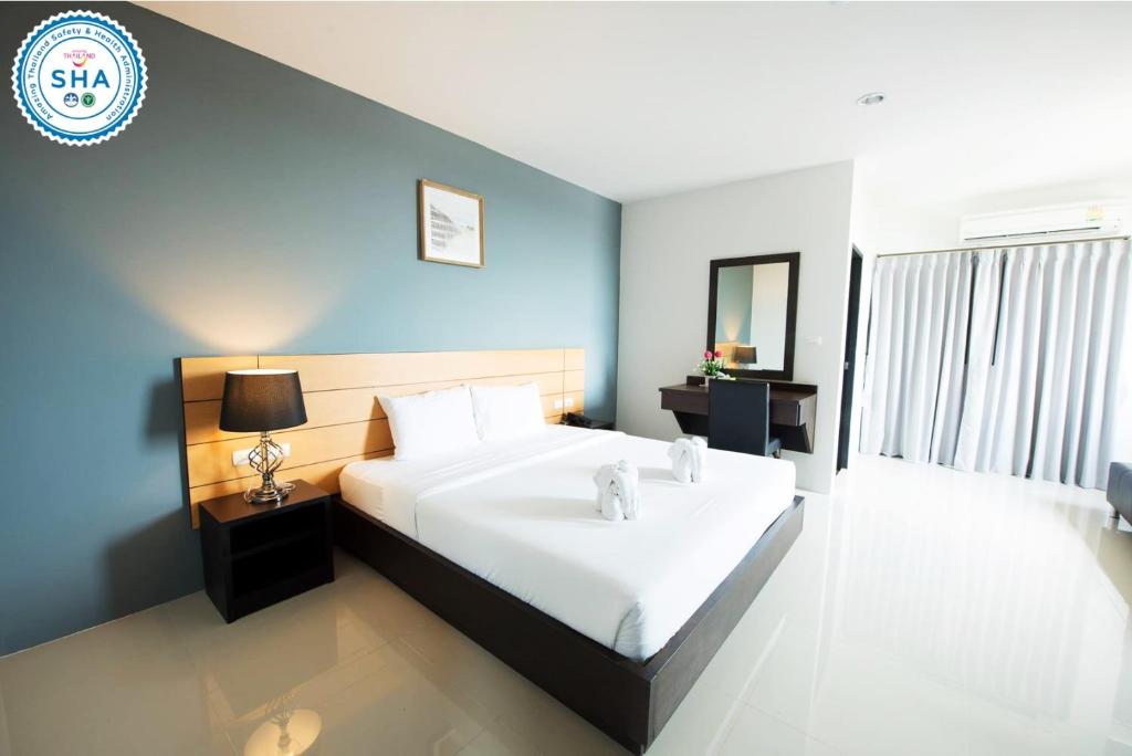 素叻利酒店的卧室配有一张白色大床和蓝色的墙壁