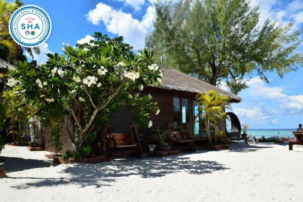 丽贝岛Anda Lipe Resort的海滩上的度假村,种有树木和白色花卉
