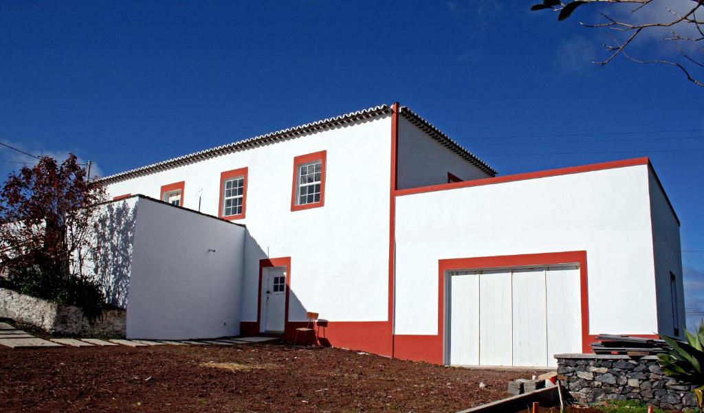 波尔图镇Casa de Almagreira - Empreendimento de Turismo em Espaço Rural - Casa de Campo的白色和红色的建筑,设有车库
