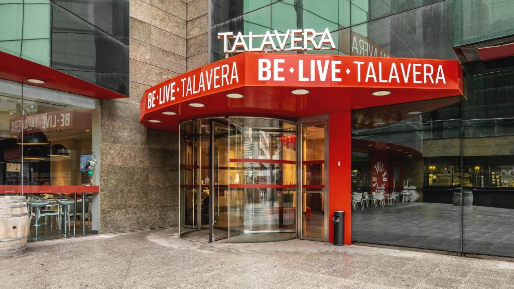 塔拉韦拉·德·拉·雷纳塔拉韦拉市中心比利酒店的带有读书主动的标志的建筑,实实在在地