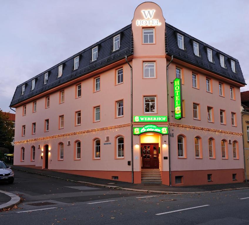 齐陶Hotel Weberhof的一座大建筑的侧面有标志