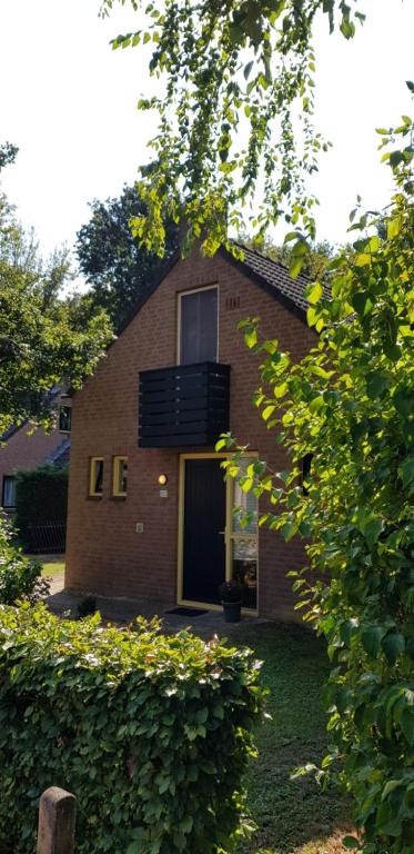 EwijkVakantiewoning Maas en Waal的砖屋,设有窗户和阳台