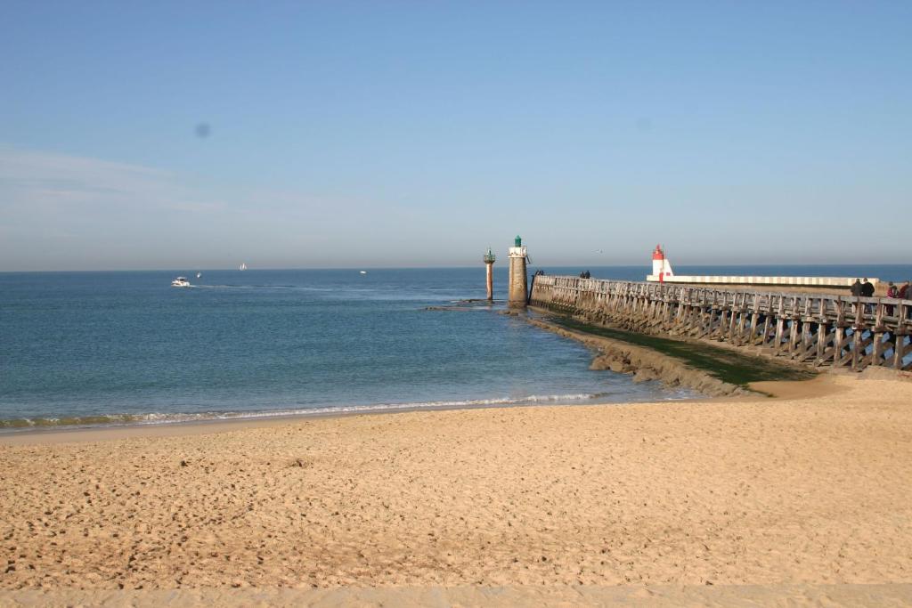 卡布勒通Studio Cap Sud Capbreton proche plage的海滩上有一个码头,水中还有一条船