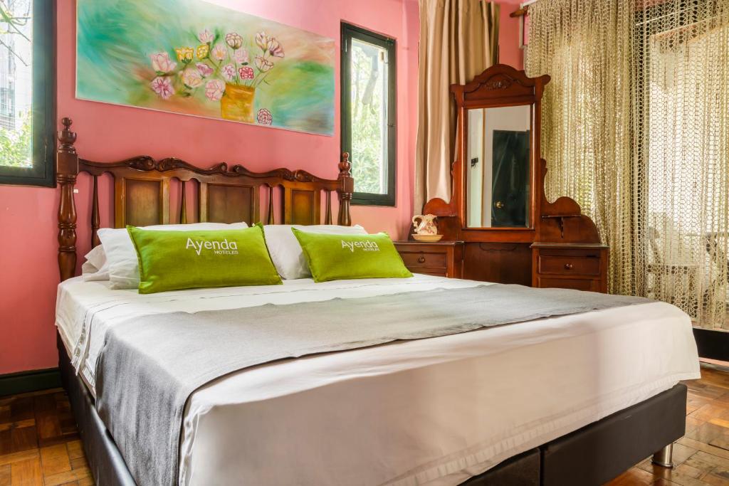 麦德林Ayenda Habana Vieja 1221的粉红色的卧室配有一张带绿色枕头的大床