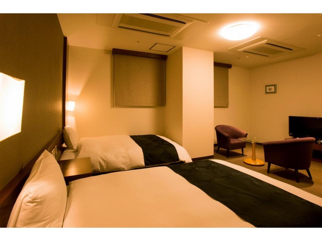 鹿儿岛Hotel Taisei Annex - Vacation STAY 05193v的配有一张床和一把椅子的酒店客房