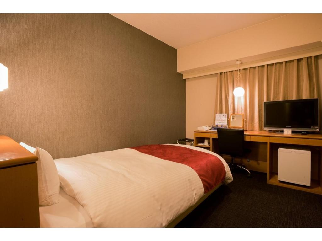 鹿儿岛Hotel Taisei Annex - Vacation STAY 04735v的酒店客房配有一张床和一张带电脑的书桌