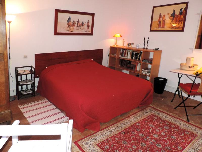 卢维耶路德斯富热尔斯尚布里住宿加早餐旅馆的一间卧室配有一张红色的大床和一张桌子