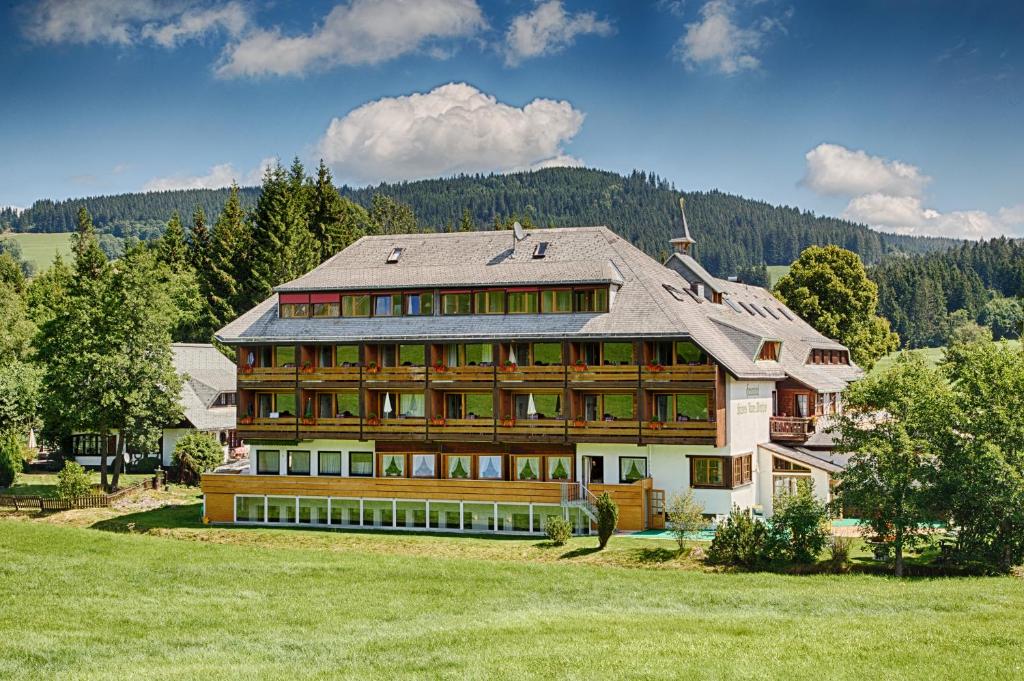 布莱特瑙Kaisers Tanne - Premium Alles Inklusive Hotel的一座带绿地的山丘上的大型房屋