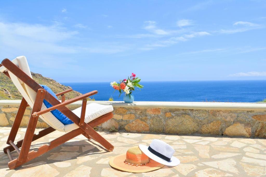 凯勒里瓦迪Panoramic Sea View Villa Saint Anna的戴帽子坐在椅子上的人