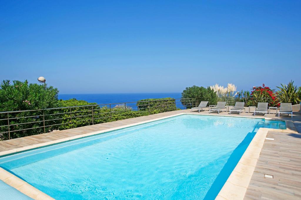 卡尔维Le Saint Erasme, Hotel Eco Friendly的一个带椅子的游泳池,背景是大海
