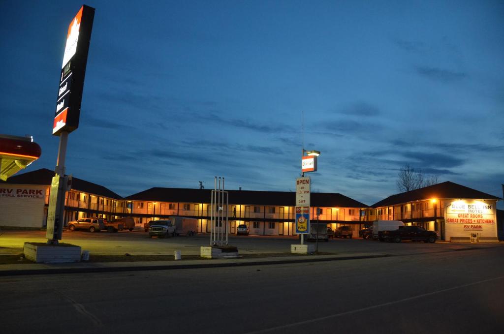 纳尔逊堡蓝钟汽车旅馆的一座有汽车在晚上停在停车场的建筑