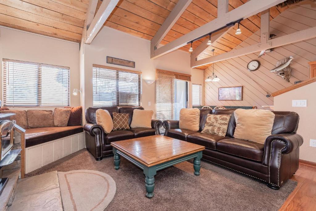 马姆莫斯湖Bigwood W #90的客厅配有皮革家具和桌子