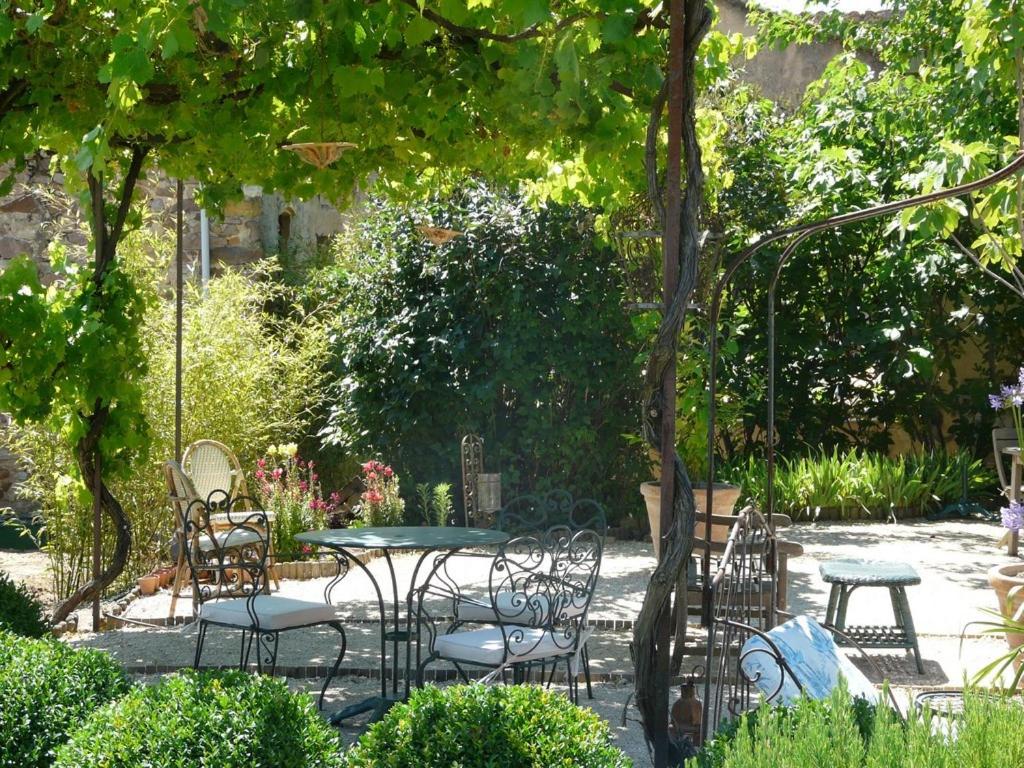 鲁西永阿姆喜酒店的花园内带桌椅的庭院
