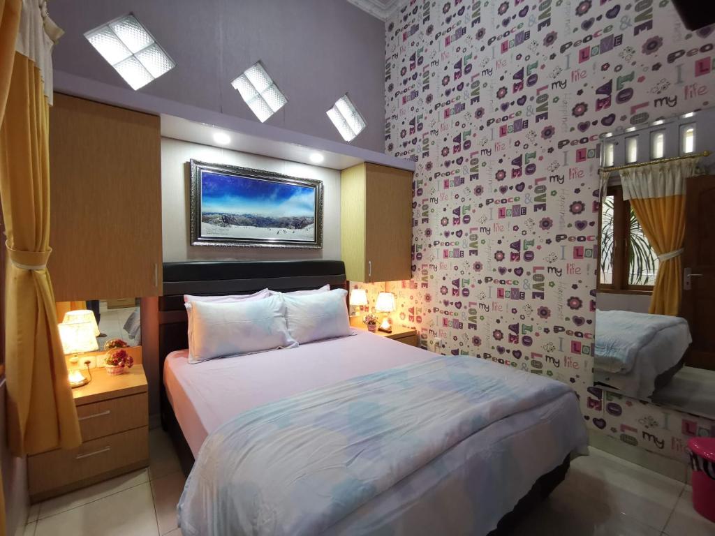 日惹纳瑞斯卡套房民宿的一间卧室设有一张床和鲜花墙