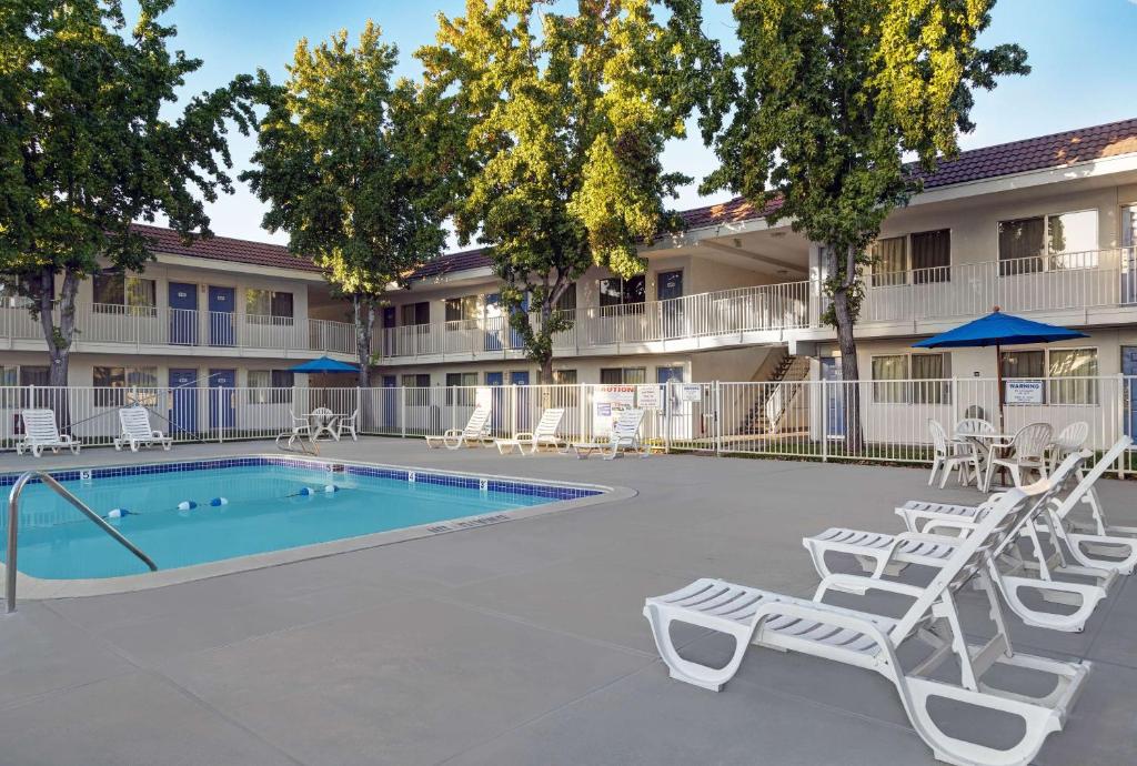 圣何塞圣荷西南部6号汽车旅馆 的一个带游泳池和椅子的庭院和一座建筑