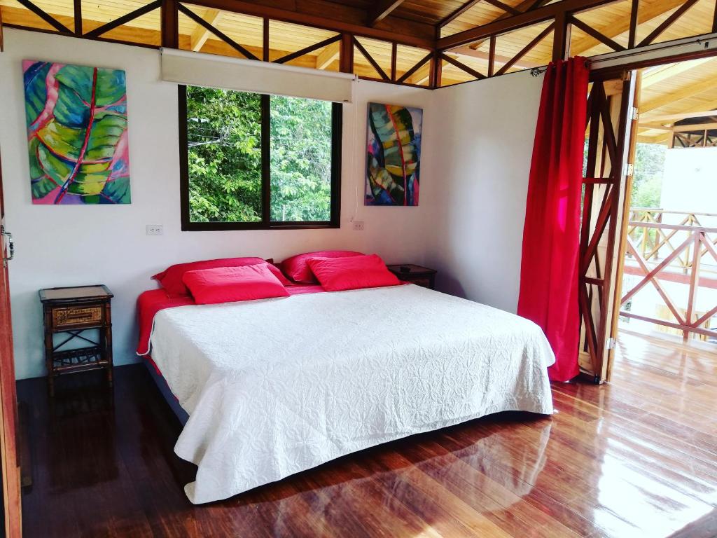 乌维塔Ibiza Tropical Beach Villas的卧室配有带红色枕头的白色床