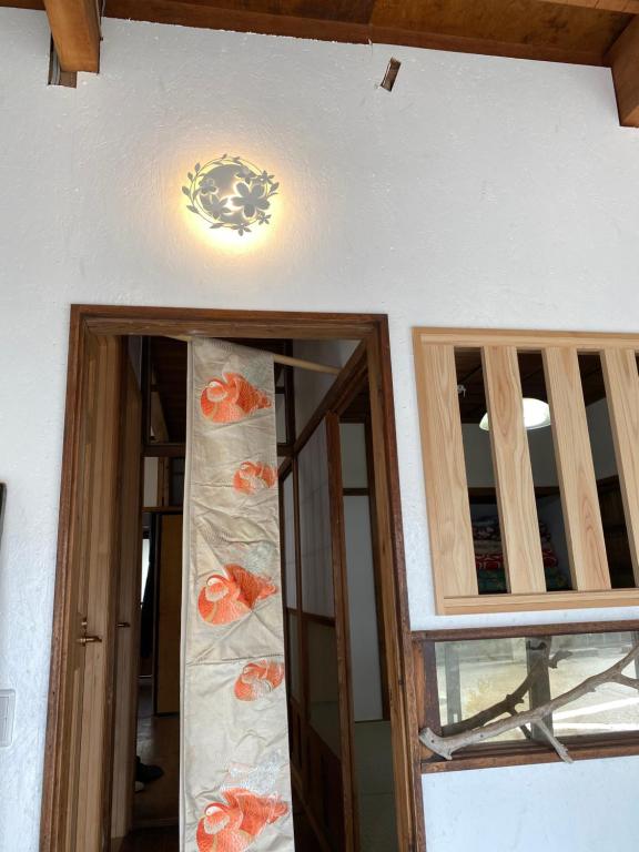 沼津沼津ライダーハウスしんちゃん的客房设有2扇窗户和墙上的吊灯。