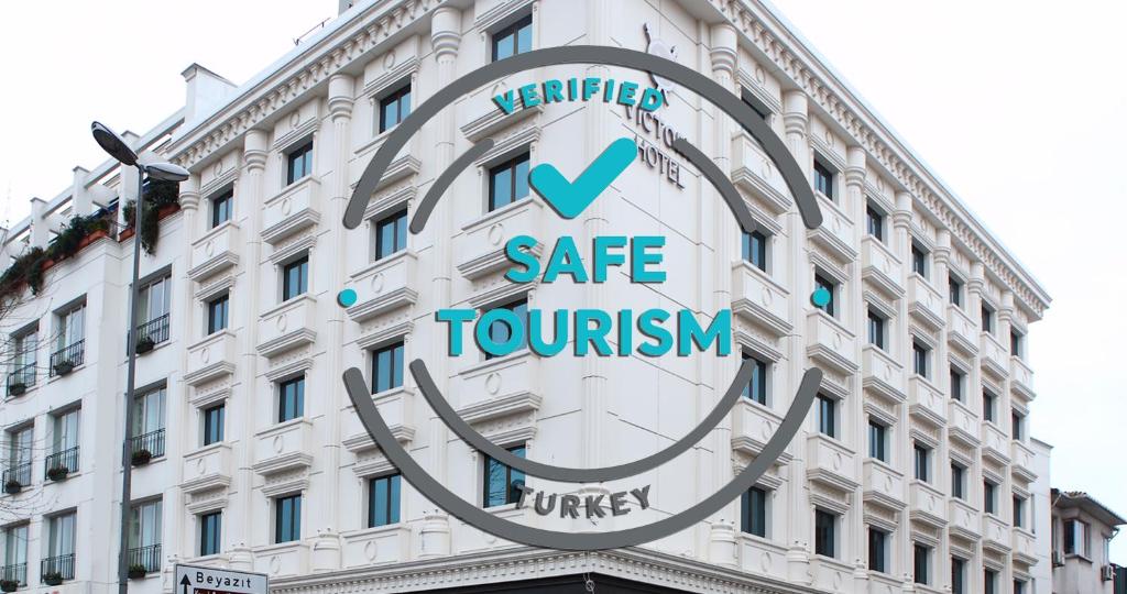 伊斯坦布尔伊斯坦布尔胜利酒店及水疗中心的一座白色的大建筑,上面有标志