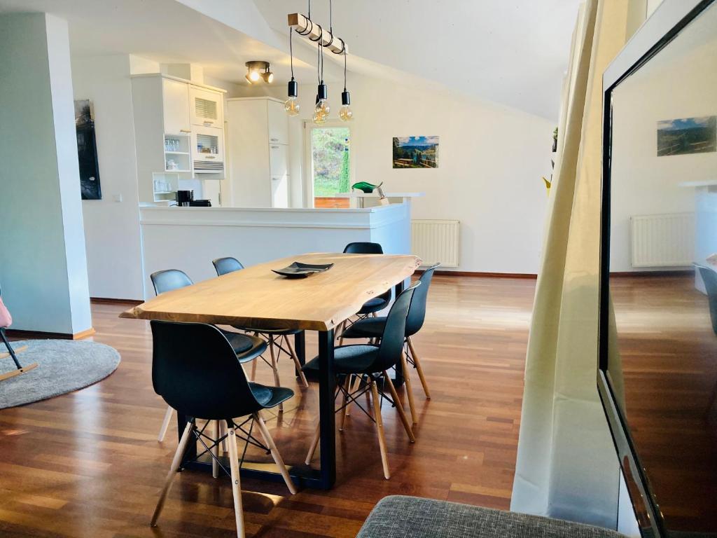 滨湖采尔Alpensoul Apartments的一间带木桌和椅子的用餐室