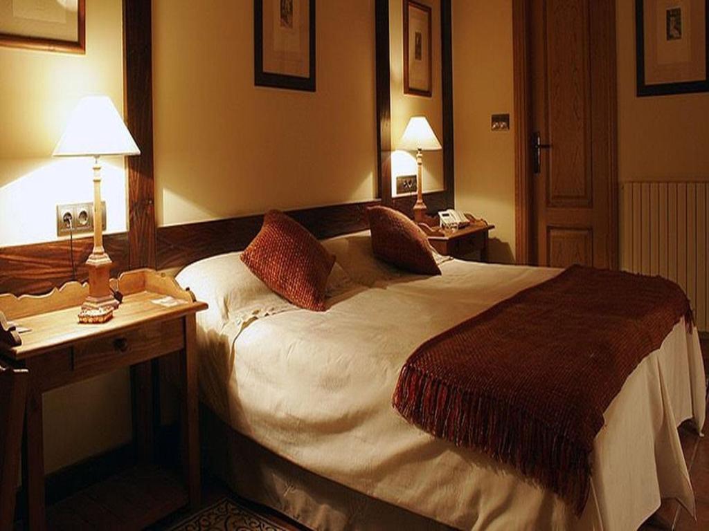 塞内圭卡斯巴斯酒店的酒店客房设有一张床和一张带两盏灯的书桌