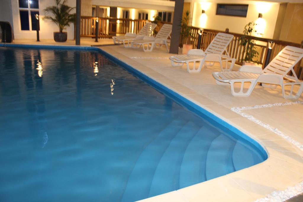 卡特勒博尔纳Sikamifer Tourist Resort的一个带躺椅的游泳池和一间酒店