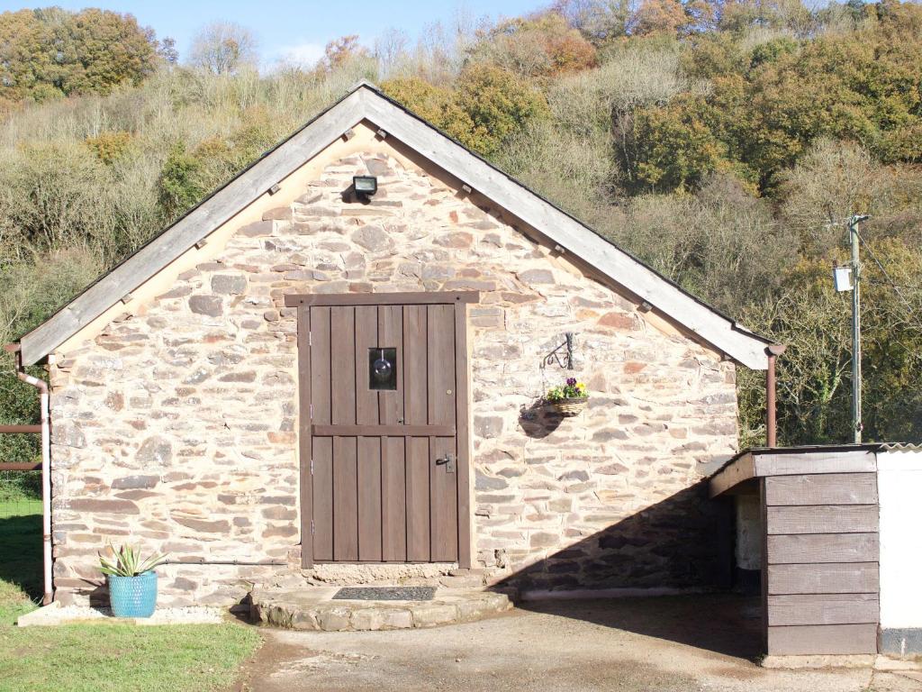 蒂弗顿Crooke Barn的一座带木门的小石头建筑