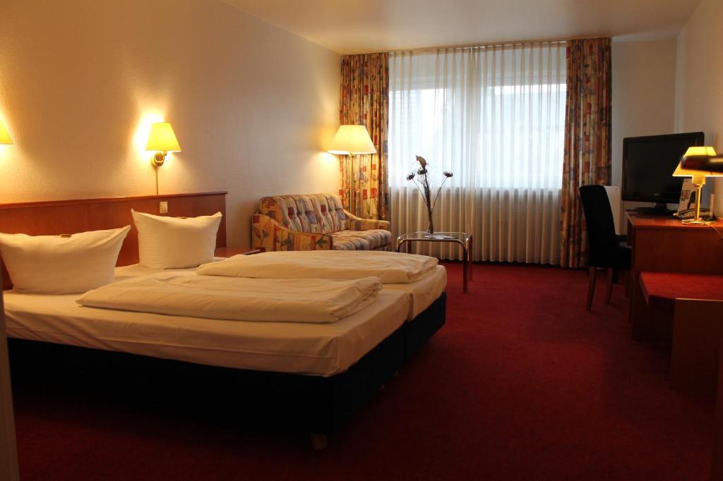 埃森埃森城市酒店的酒店客房带一张大床和一把椅子