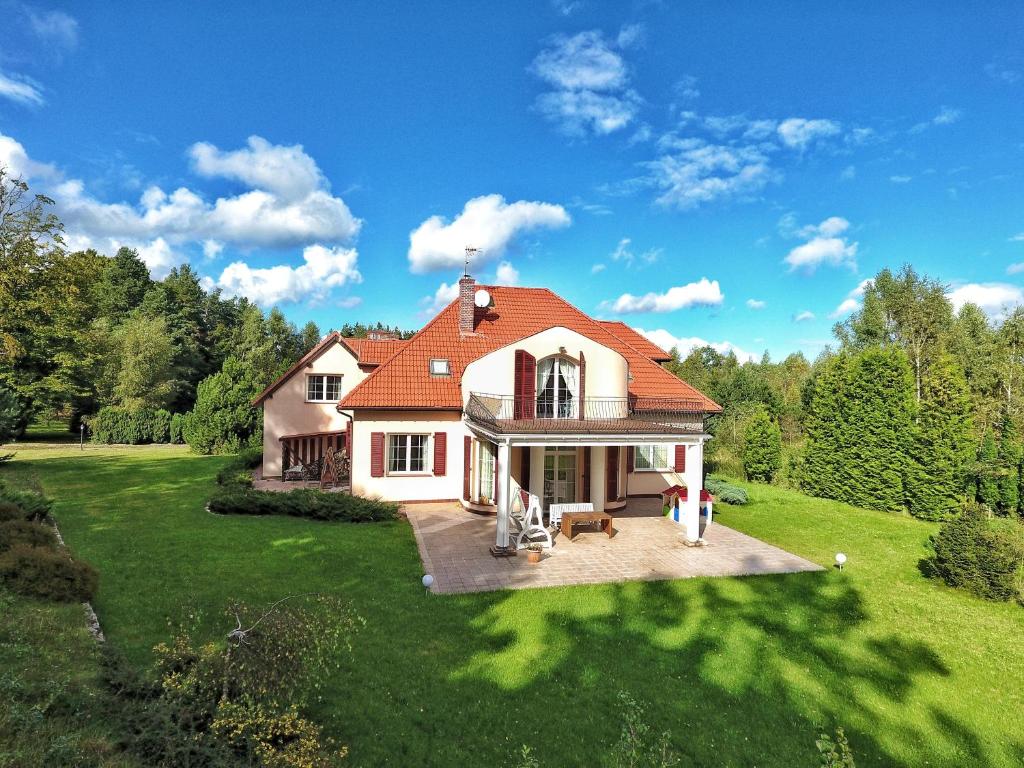 BarwikDom Wakacyjny的绿色田野上一座红色屋顶的房子