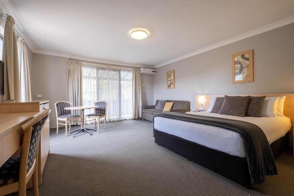 坎贝尔敦马克林汽车旅馆的一间卧室配有一张床、一张桌子和一张沙发