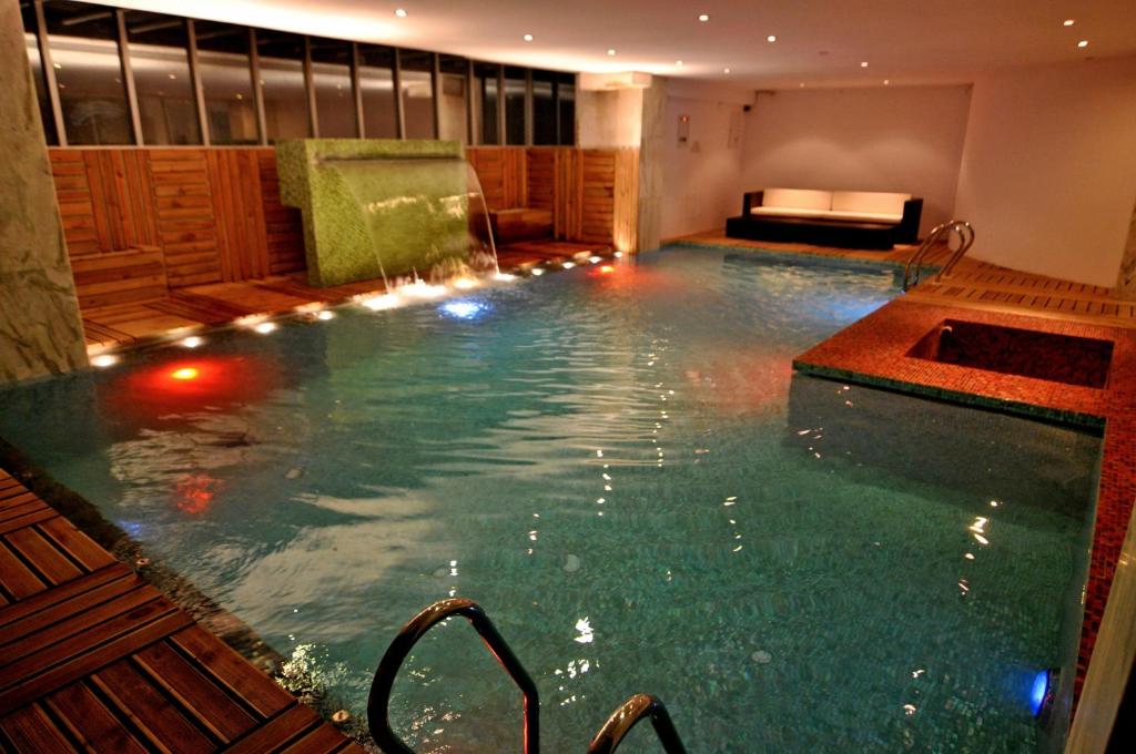 达卡海特当代公寓酒店的酒店内带灯光的游泳池