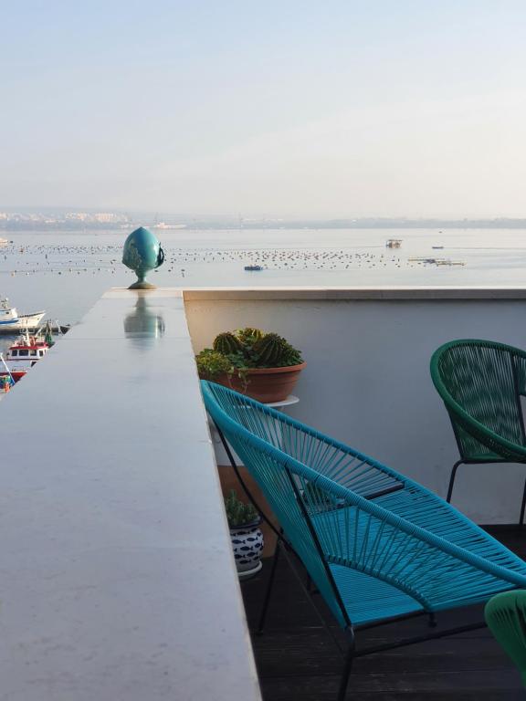 塔兰托B&B La Terrazza di NonnAnna的阳台配有桌椅,享有水景