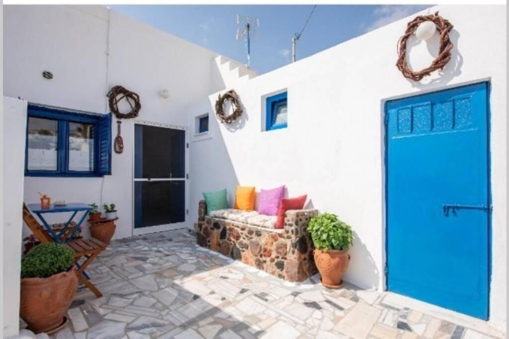 Éxo Goniáeasy going santorini house的客厅设有蓝色的门和沙发