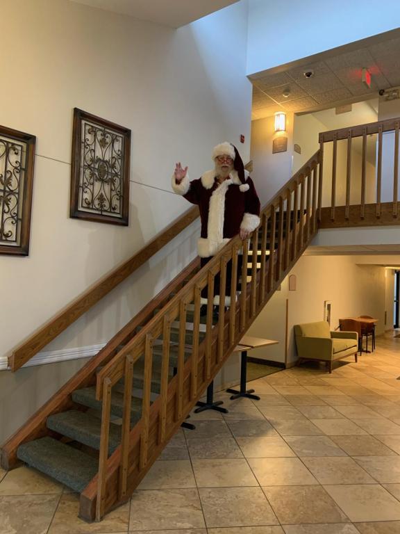 HastingsNichols Inn & Suites的站在楼梯上,身着桑塔克劳斯的男人