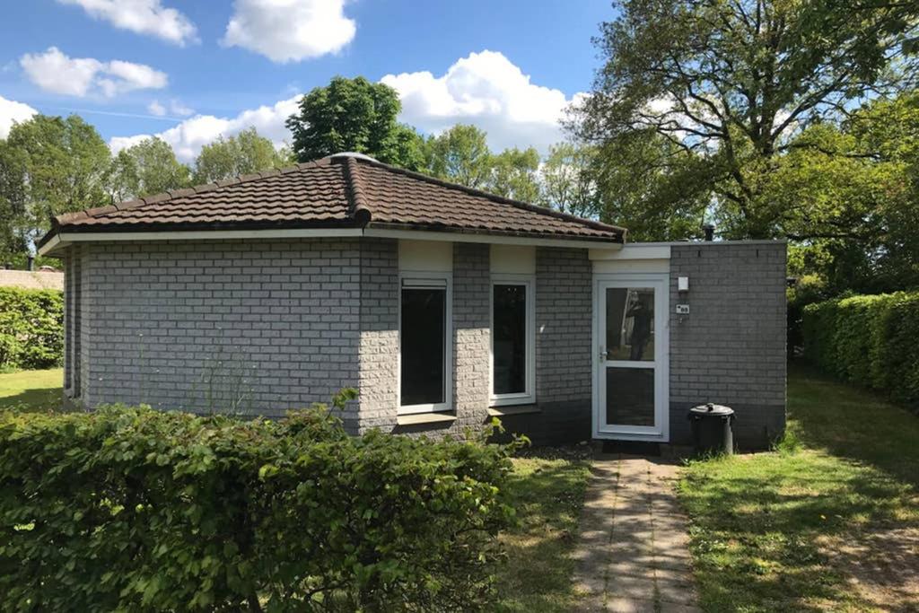 哈弗尔特Rustig gelegen bungalow in mooi Havelte (Drenthe)的白色门的小砖屋