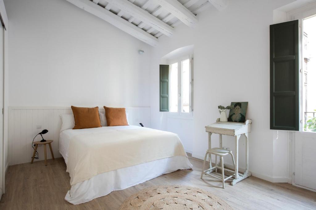 巴塞罗那CASA FILOMENA的白色卧室配有床和凳子