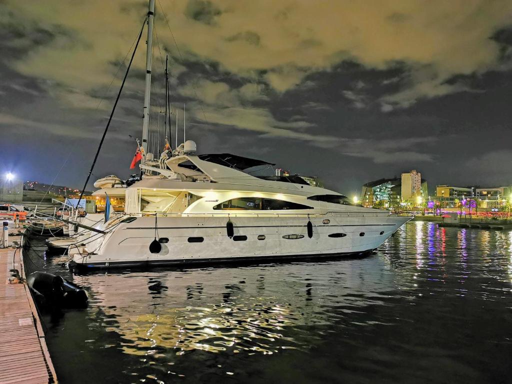 巴塞罗那Rent Luxury Motor Yacht的白船在夜间停靠在水中