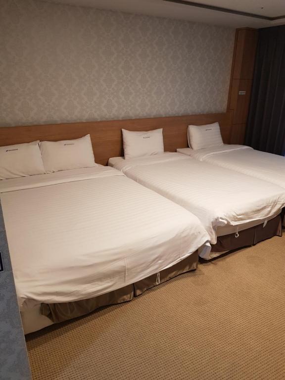襄阳郡YangYang International Airport Hotel的两张睡床彼此相邻,位于一个房间里