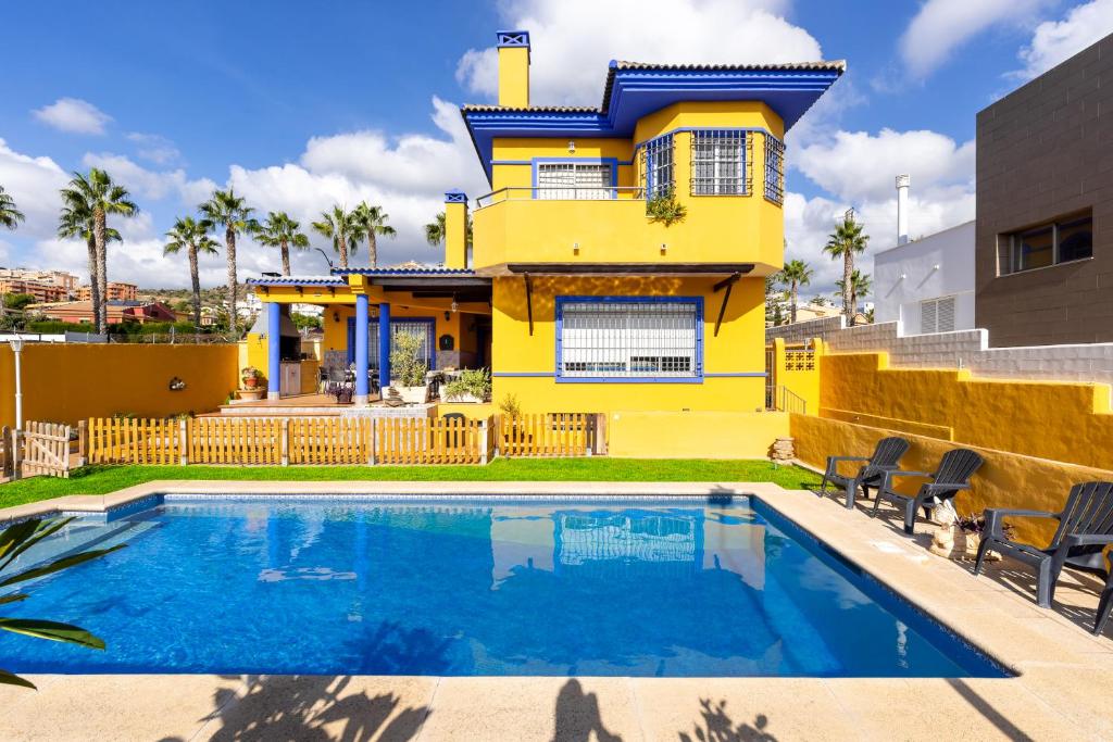 林孔-德拉维多利亚Milestone House的黄色的房子,前面有一个游泳池