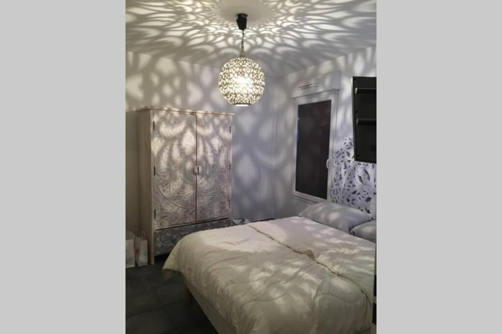 尼斯Le Gallienice au cœur de la ville的一间卧室配有一张床和一个吊灯