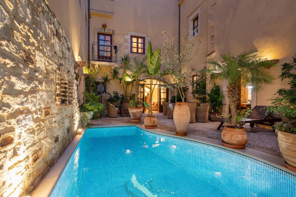 罗希姆诺帕拉齐诺帝科里纳酒店的植物丛中的一个游泳池