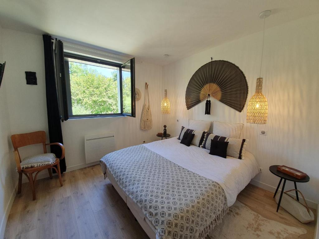 亚眠"Au jardin sur l'eau"的一间卧室设有一张大床和一个窗户。