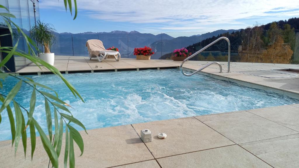 Vaneze邦多纳山脉酒店的一个带椅子的游泳池,背景是群山