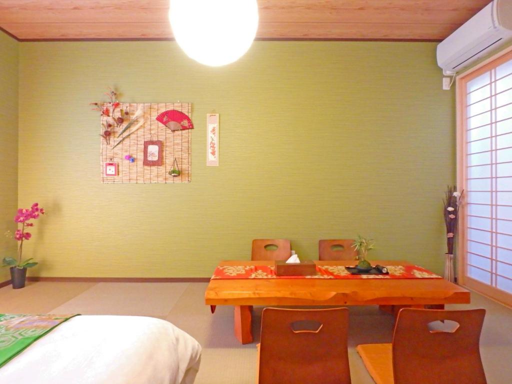 京都Fukenouchi House的一间设有绿色墙壁、桌子和椅子的用餐室
