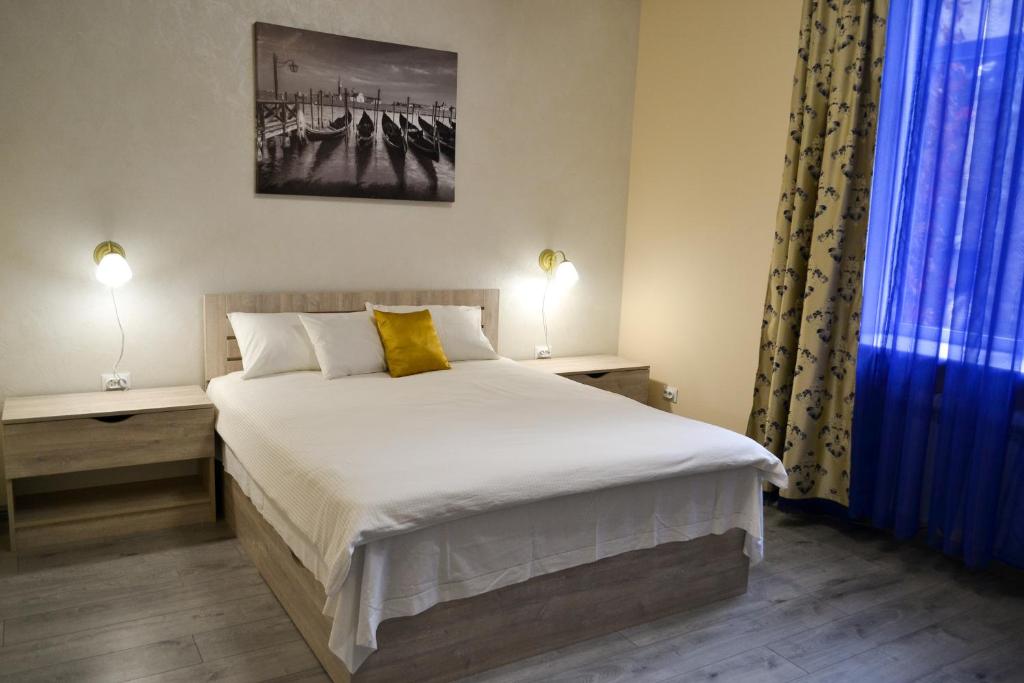 利沃夫Aquamarine apartments Lviv的一间卧室配有一张床、两盏灯和一个窗户。
