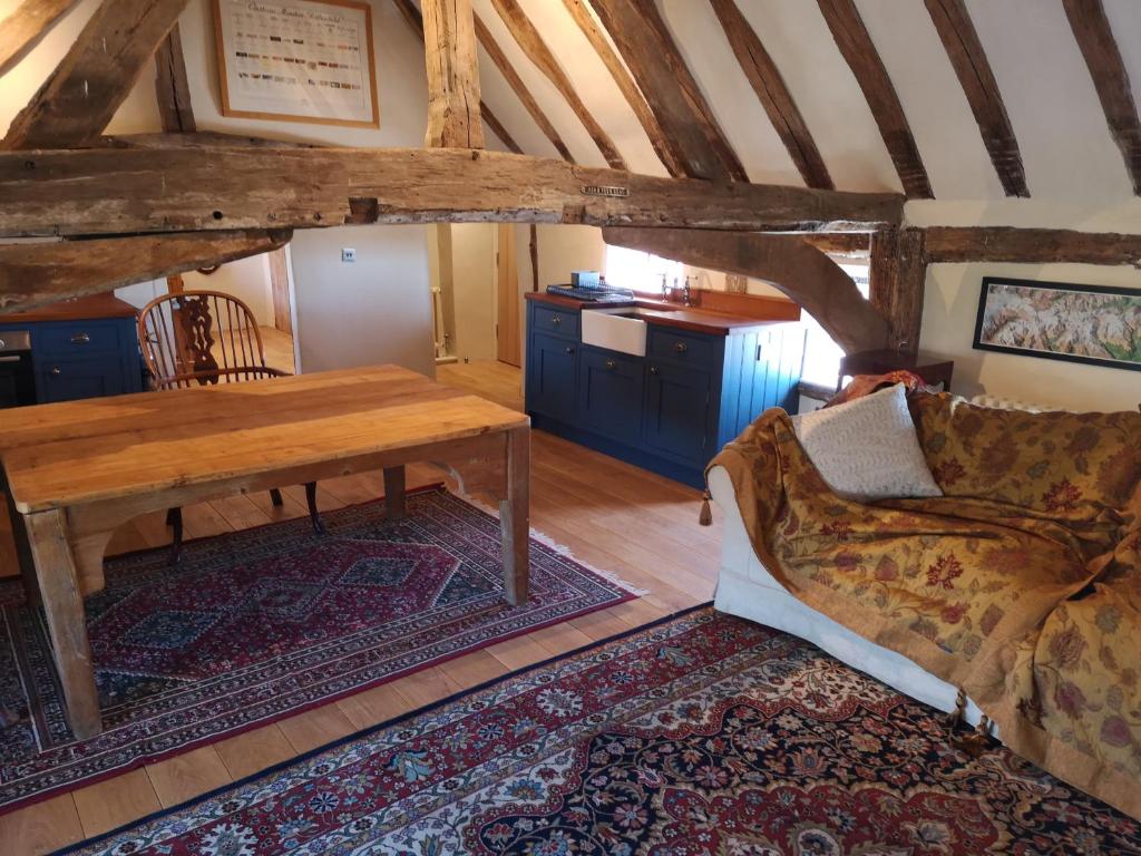 HawkedonThe Queen's Head的客厅配有木桌和沙发