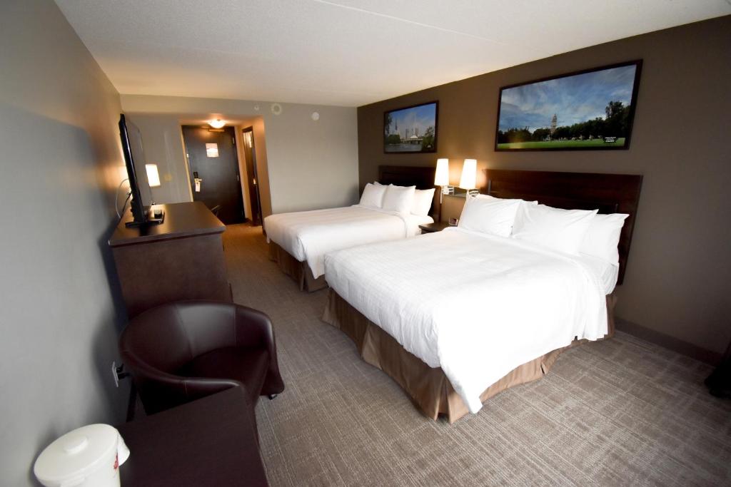 温尼伯Canad Inns Destination Centre Club Regent Casino Hotel的酒店客房,配有两张床和椅子
