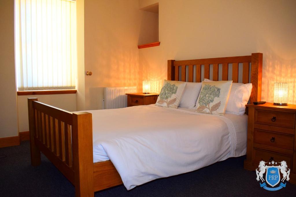 埃尔金Two Bedroom Town Centre Apartment的卧室配有一张带白色床单和枕头的大床。