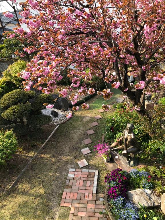 京都Sakura house的一座种有粉红色花卉的花园